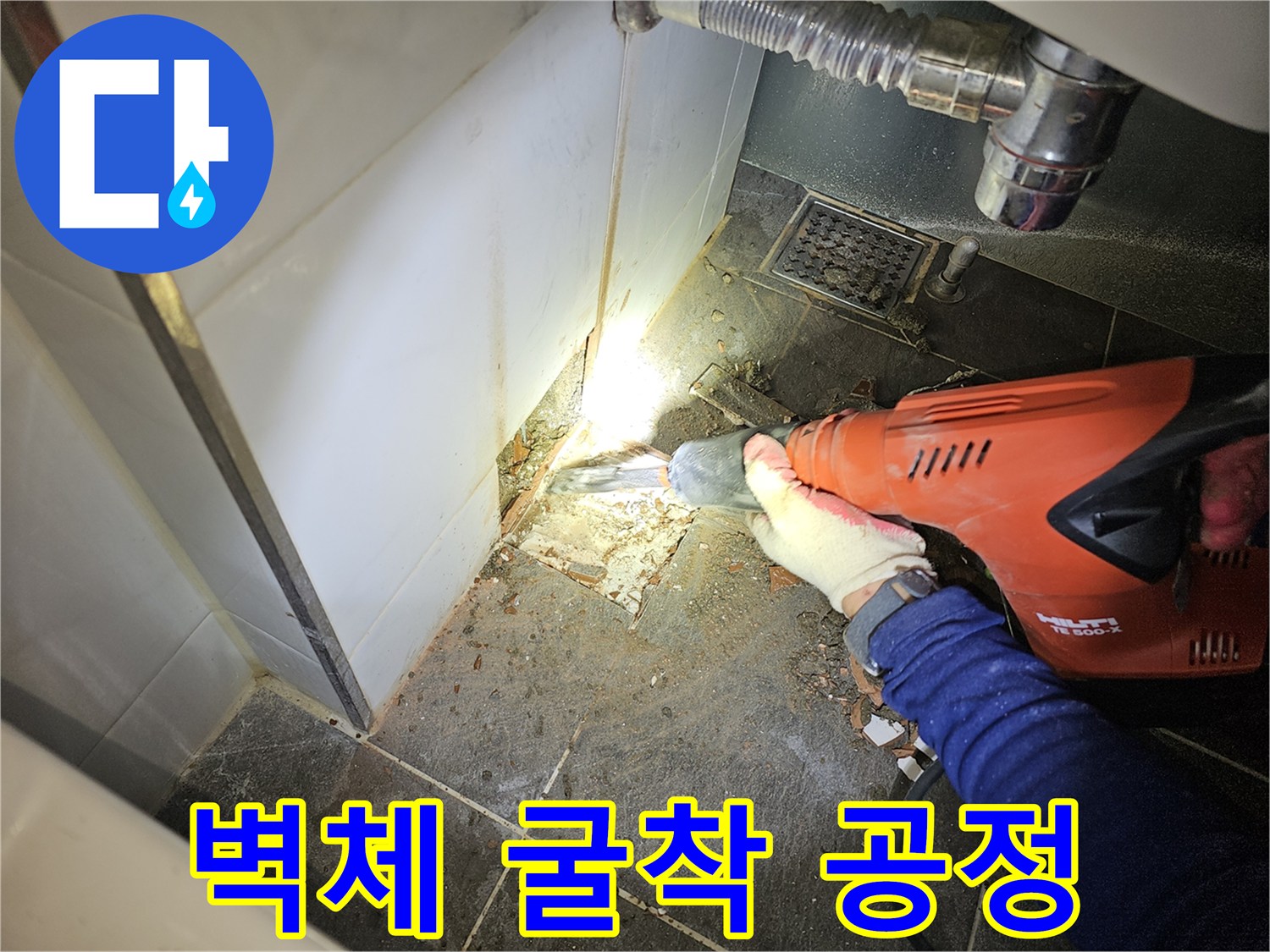 누수 지점을 찾기 위해 타일을 제거하고 벽을 파내는 작업 모습