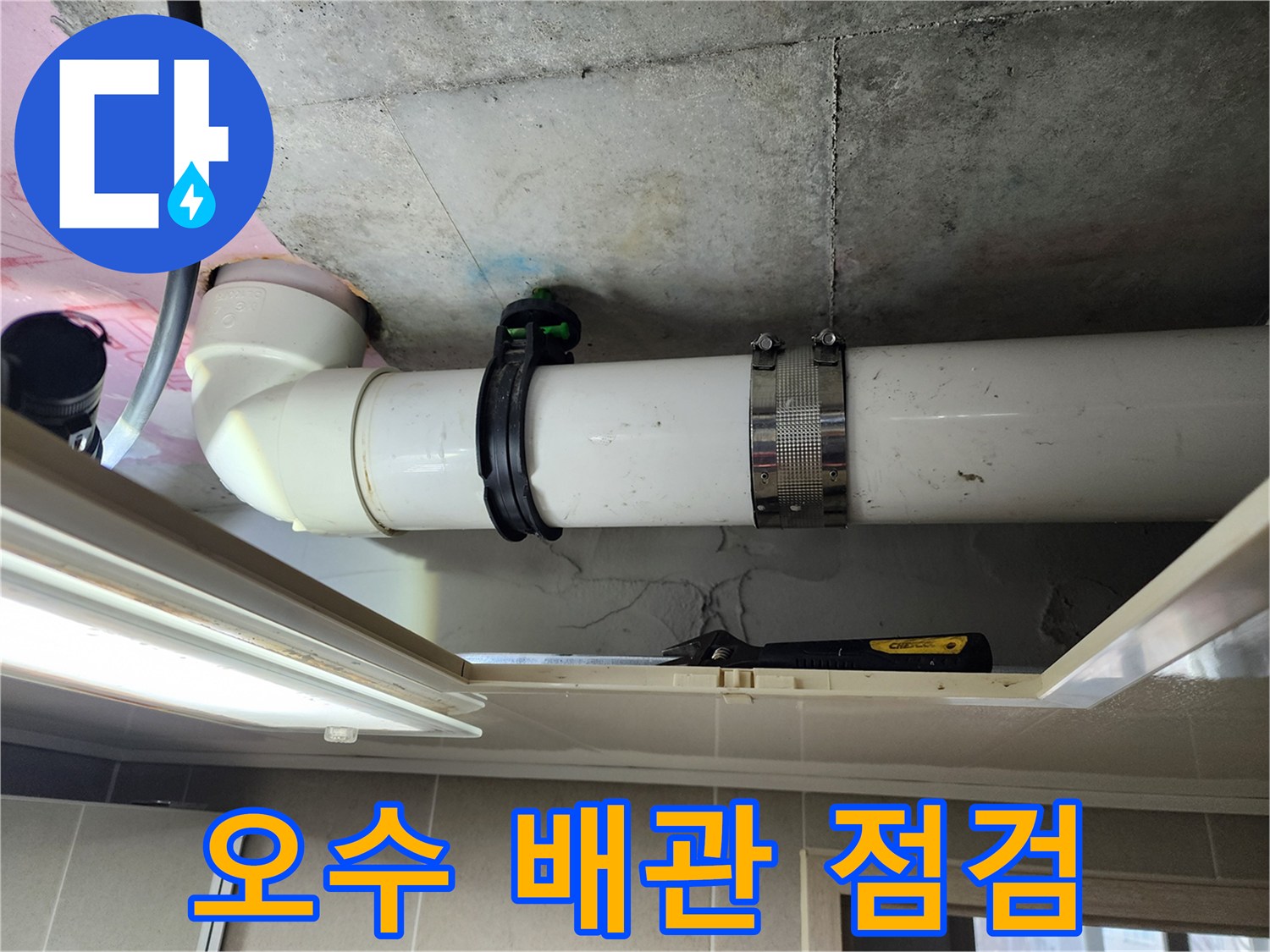 천장 내부의 흰색 PVC 관과 검은색 고정 장치를 촬영한 사진