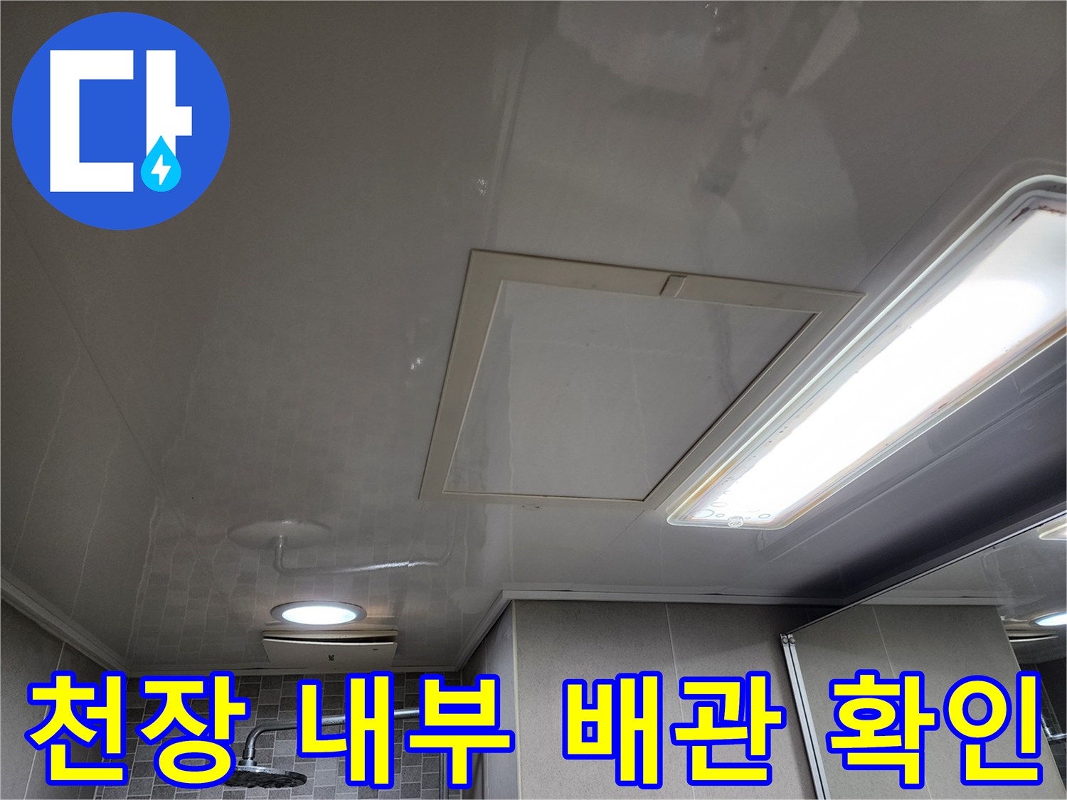 화장실 천장재 사이로 보이는 점검구와 조명 시설