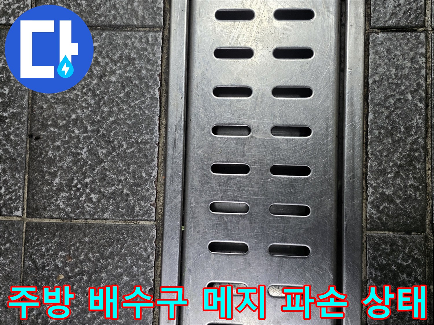 스테인리스 배수구와 틈새가 벌어진 타일 바닥