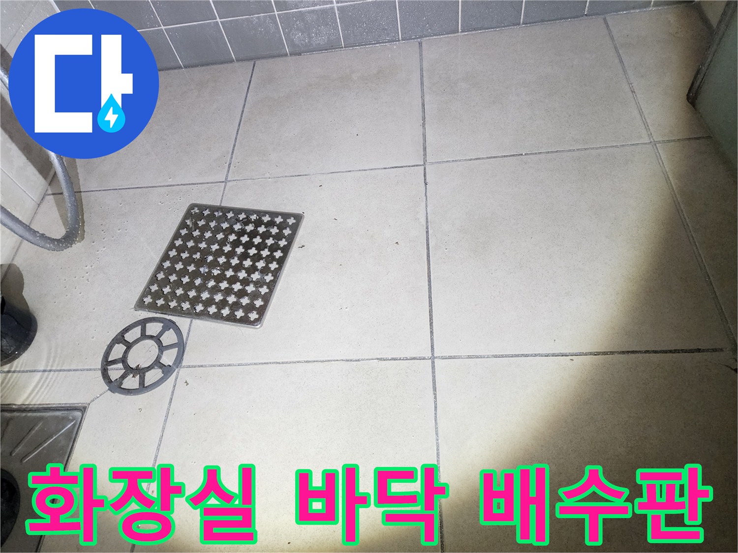 화장실 내부의 배수 유닛과 사각형 타일 바닥면입니다.