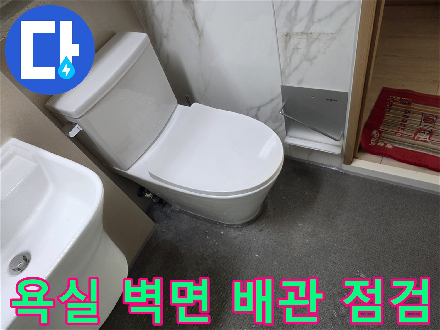 한샘 판넬 마감된 화장실 내부의 변기 및 세면대 모습