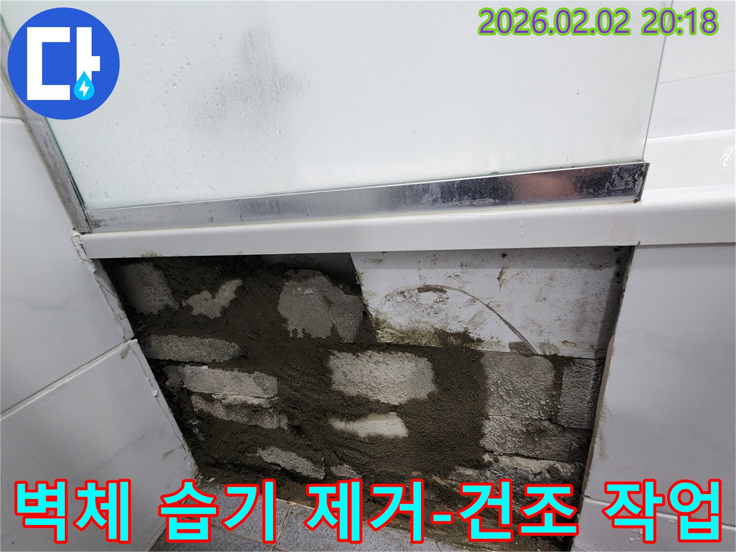 욕실 벽면의 타일을 제거한 후-내부에 스며든 습기를 제거하고-건조 작업을 진행하는-공사 현장 사진입니다.