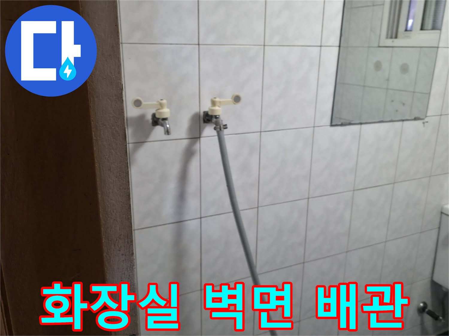 하얀색 타일 벽면에 설치된 수도꼭지와 연결 호스 모습