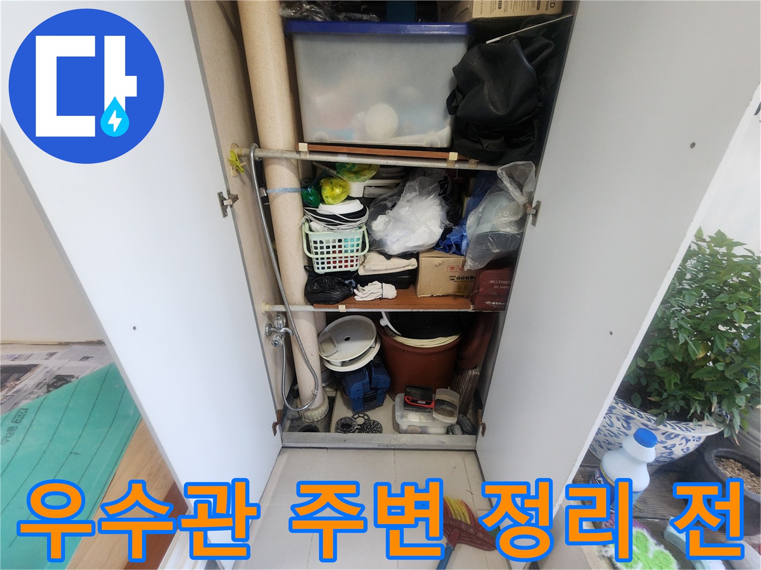 베란다 수납장 안에 우수관이 있습니다-다양한 물건들이 정리되어 있지 않은 상태입니다-누수 탐지를 위한 현장 사진입니다