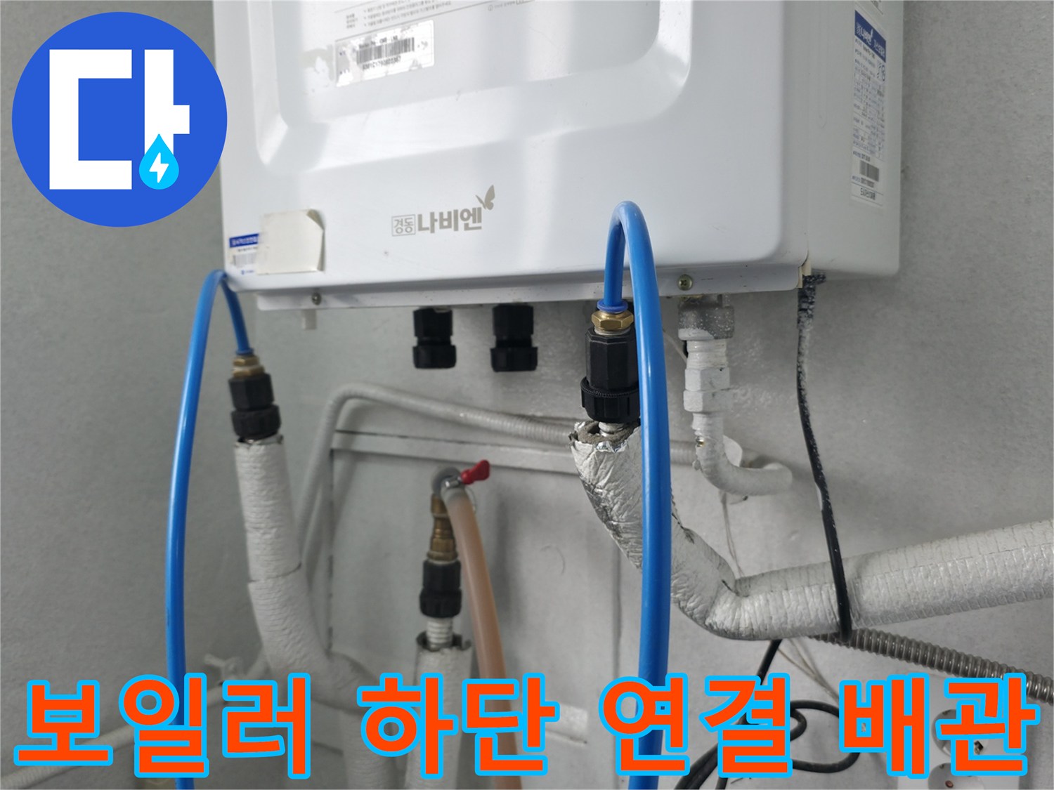 보일러 아래에 설치된 파란색 호스와 흰색 배관의 상세 모습
