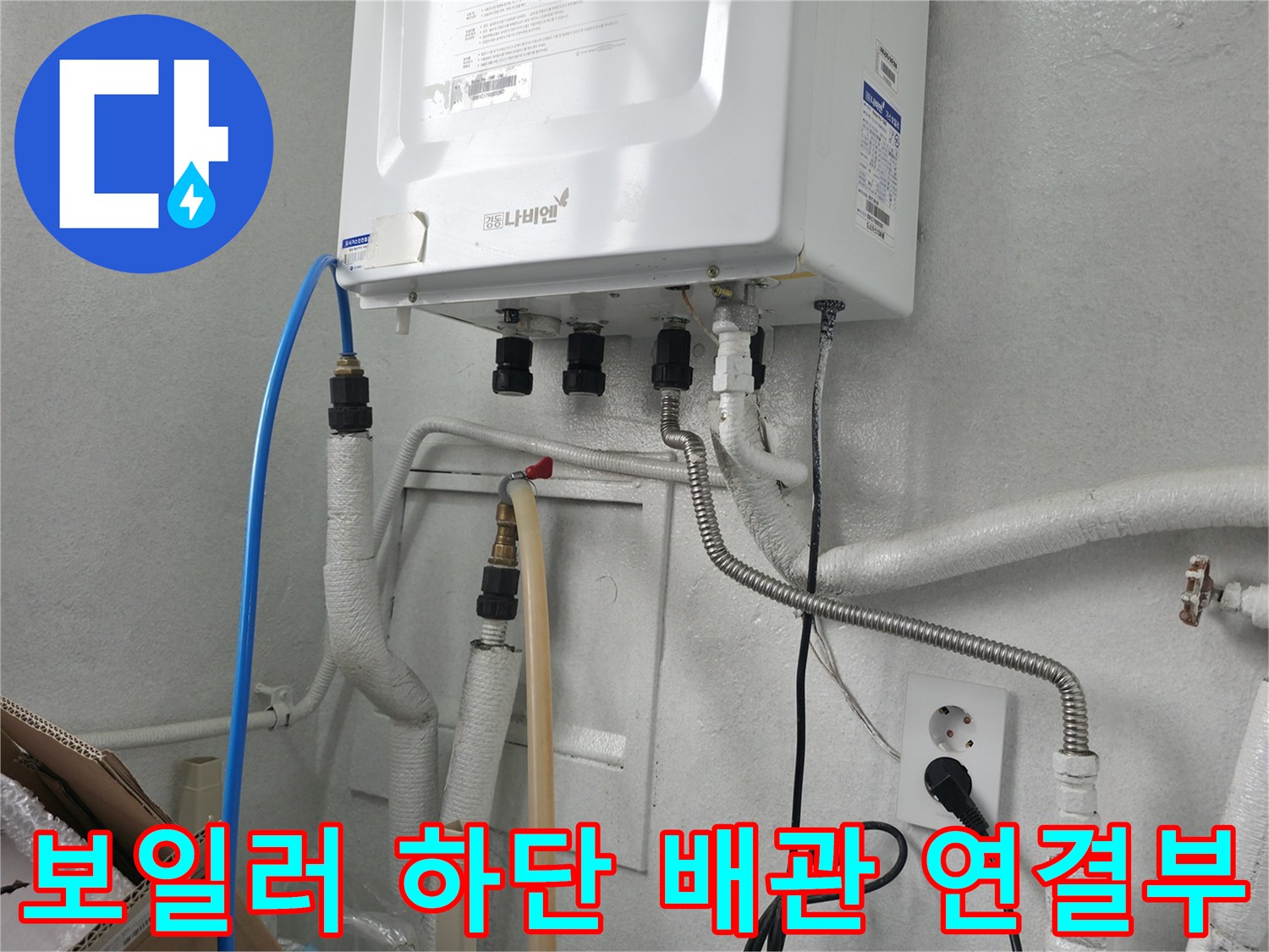 보일러 아래쪽의 파란색 호스와 은색 주름관이 연결된 모습입니다.