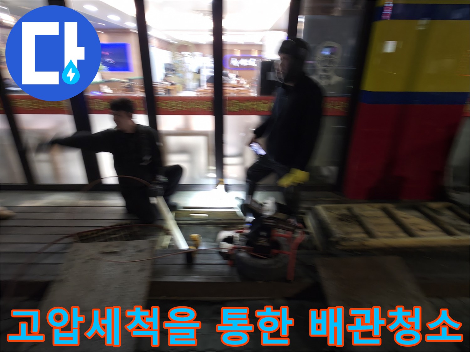 전문 인력이 고압 세척기를 조작하여 식당 배관을 정비하는 모습