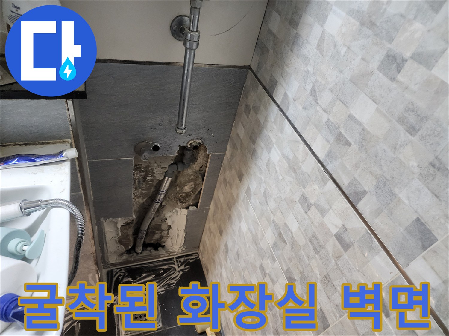 벽면 내부의 은색 급수 배관과 젖은 시멘트 부위 노출