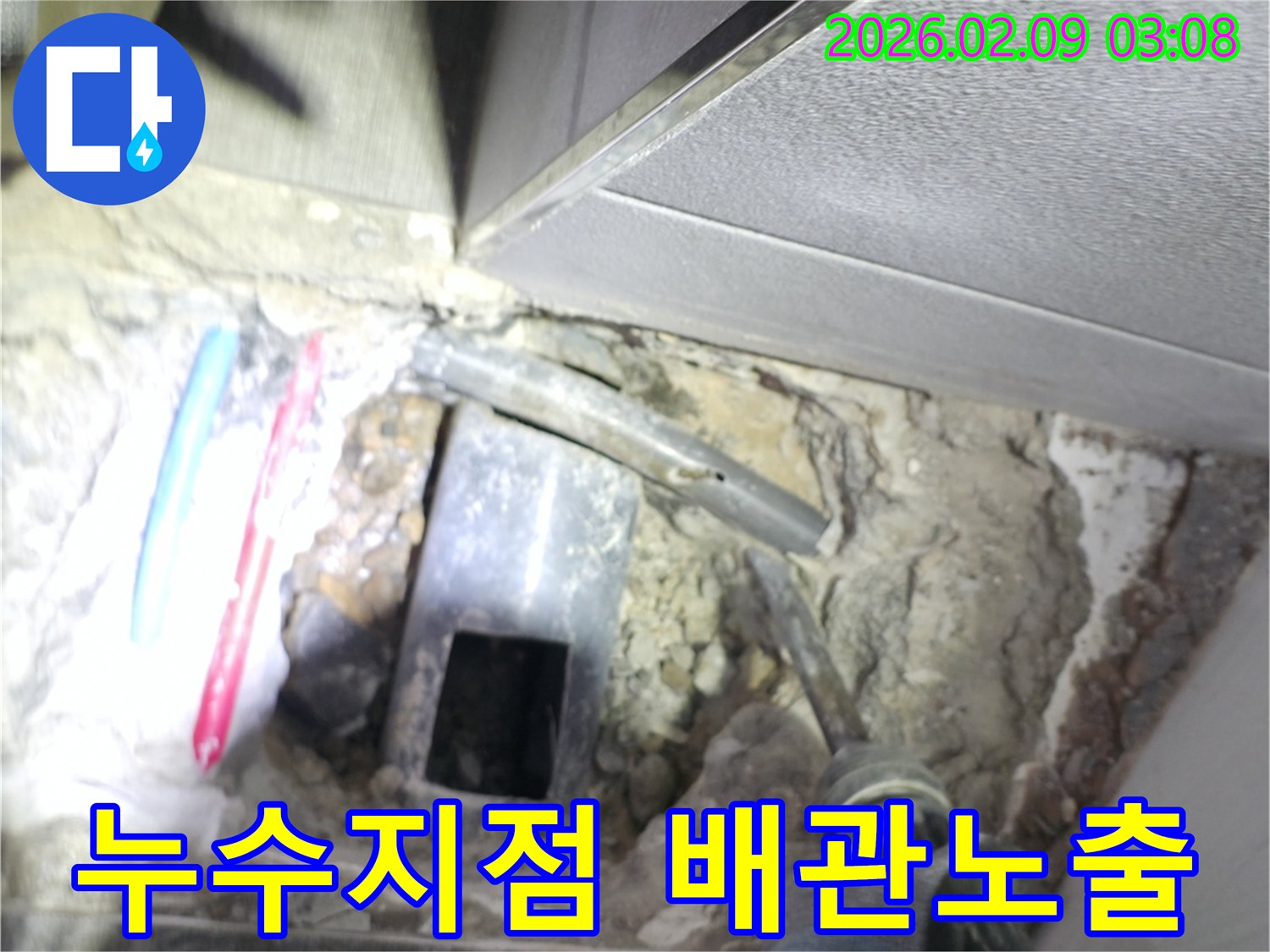 누수 지점의 바닥을 파쇄하여 손상된 배관을 노출시키고 수리 준비를 하는 작업 현장