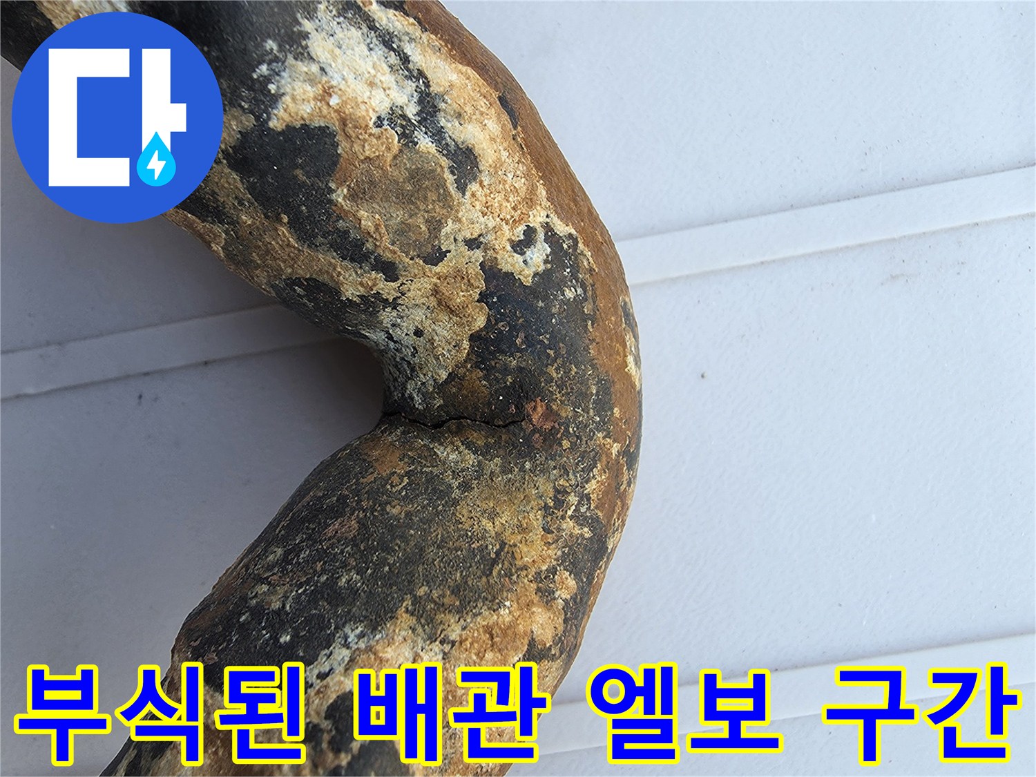 심하게 부식되어 구멍이 난 금속 배관의 꺾임 부위