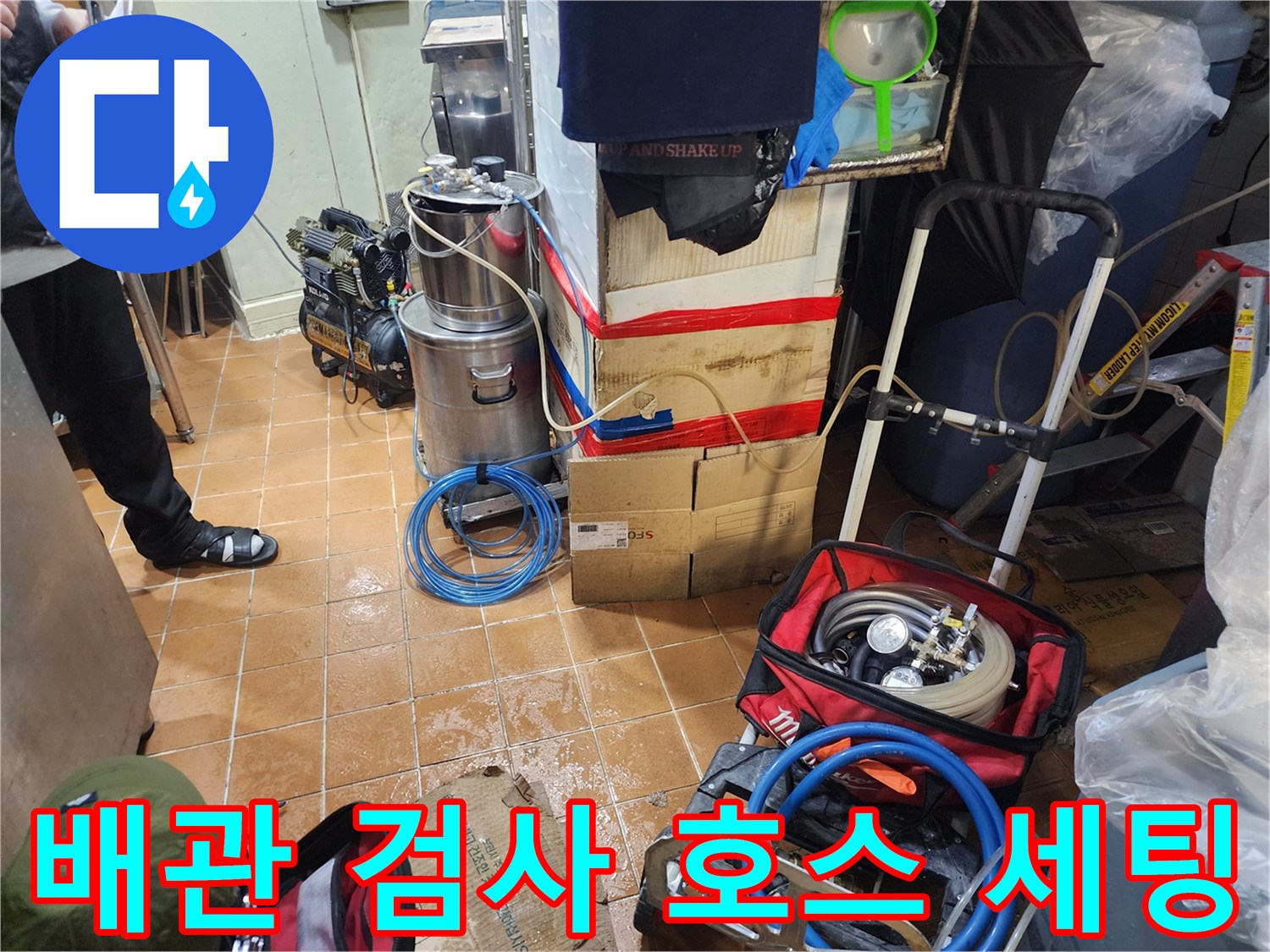 바닥에 놓인 파란색 압력 테스트용 호스와 장비