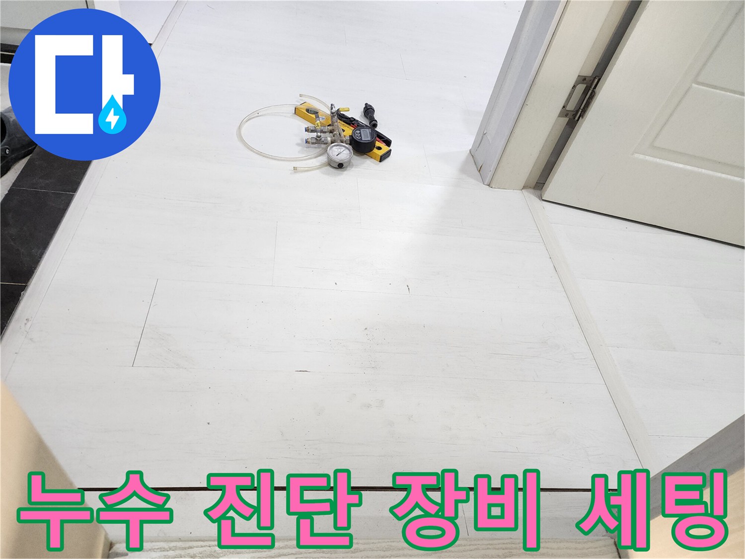 하얀색 타일 바닥 위 배치된 누수 탐지용 압력계와 호스