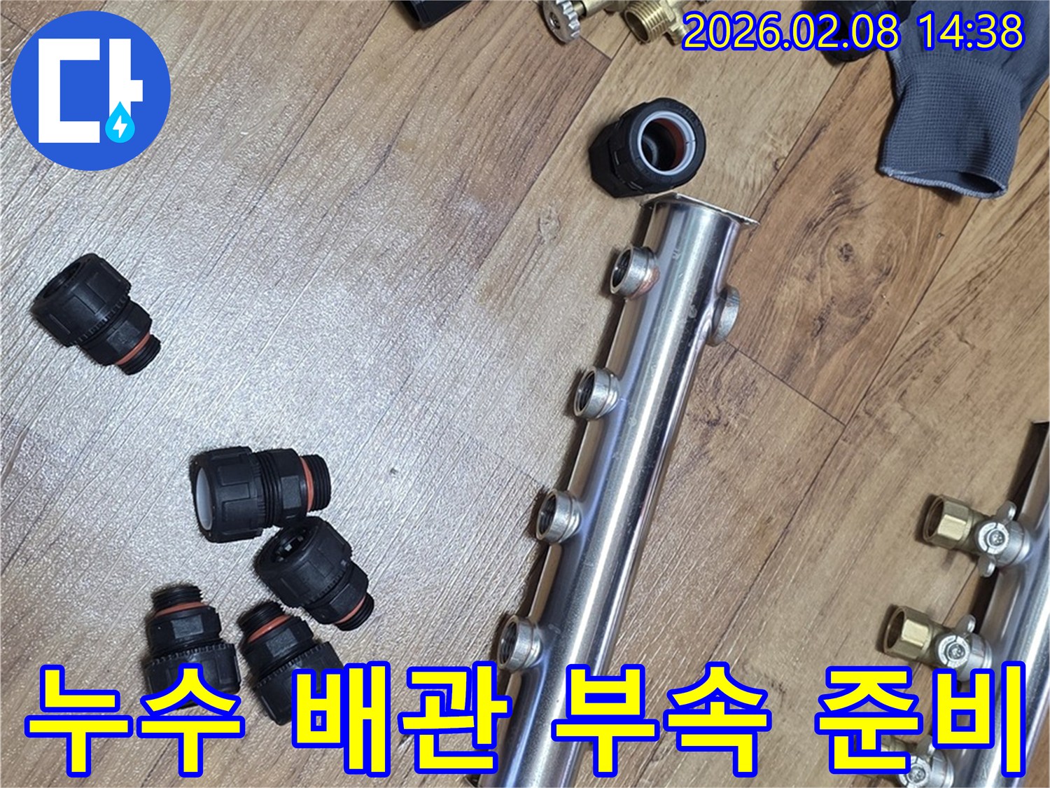 누수 공사에-사용될-새로운-배관-분배기와-연결-부속들이-바닥에-정돈되어-있습니다