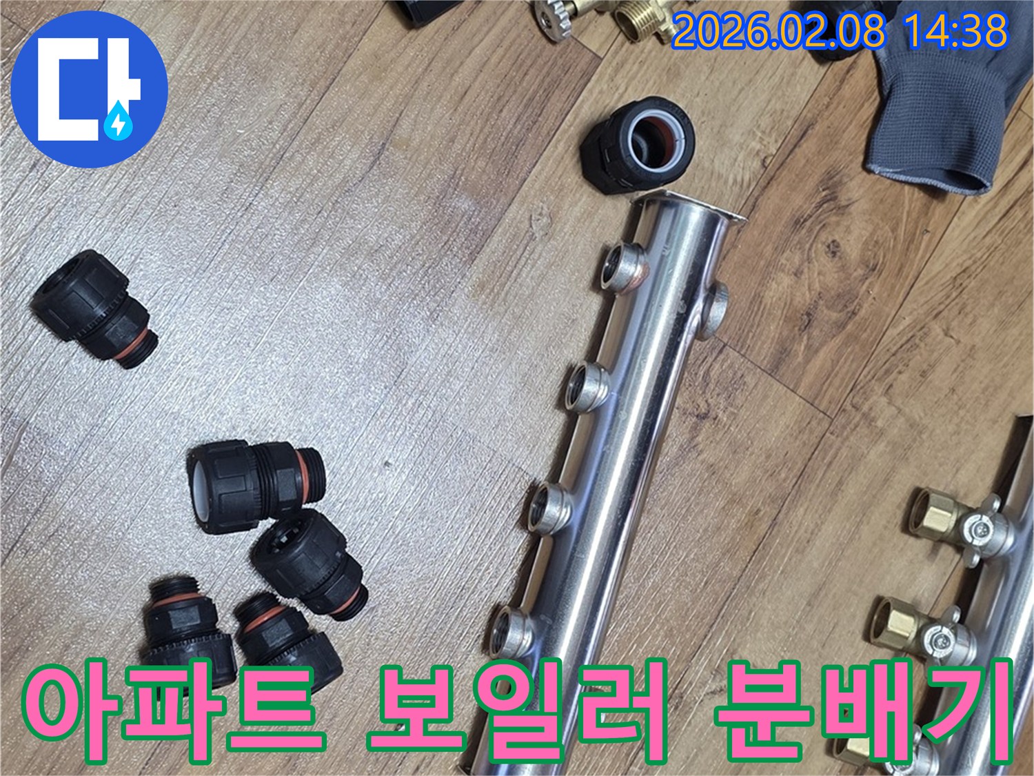 아파트 누수 문제 해결을 위해-새 보일러 분배기와-다양한 배관 연결 부속들이-작업 현장에 놓여 있습니다