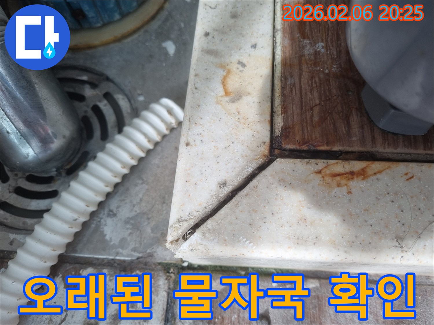 배수구 옆-오랜 기간 물이 새면서 생긴-녹슨 물때와-오염된 표면을 보여주는-누수 현장 사진입니다.