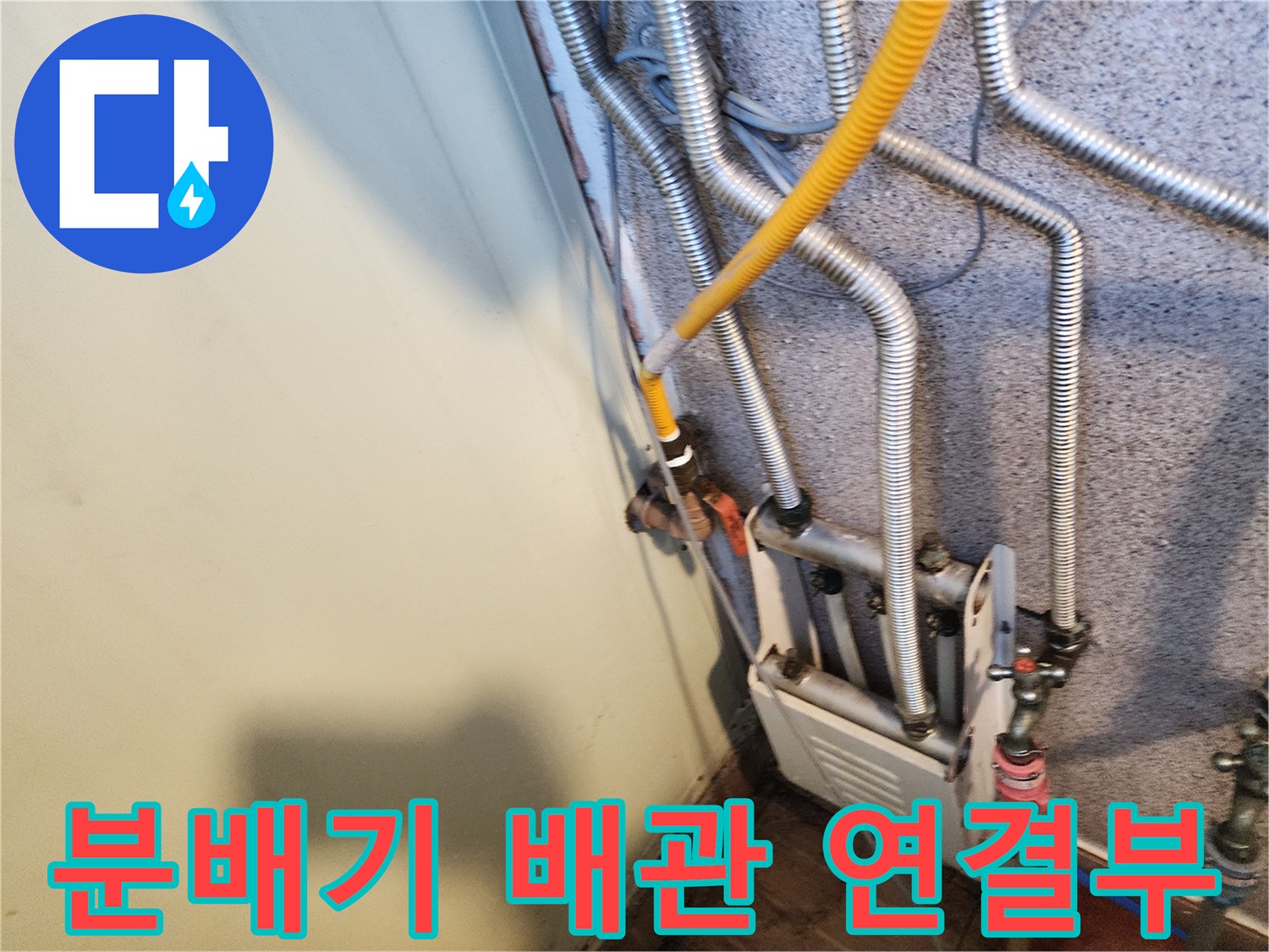 은색 주름관과 노란 호스가 연결된 보일러 분배기 설비 모습