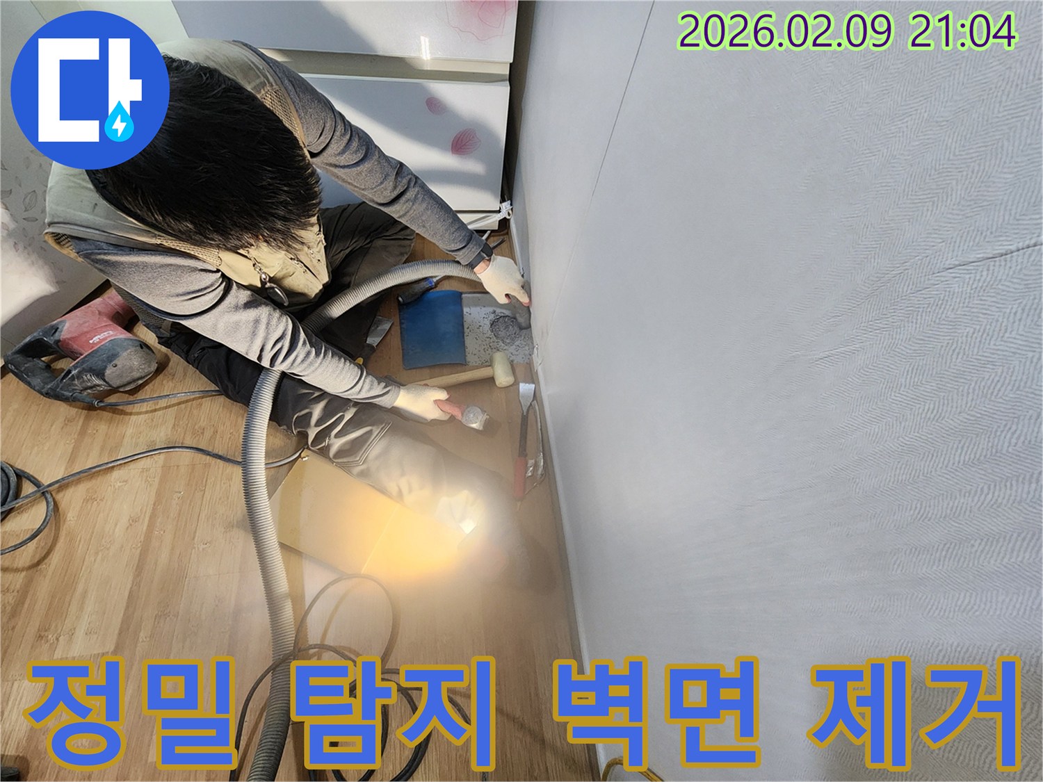 숙련된 누수 엔지니어가 정밀한 누수 탐지를 위해 벽면 마감재를 조심스럽게 제거하고 있습니다.