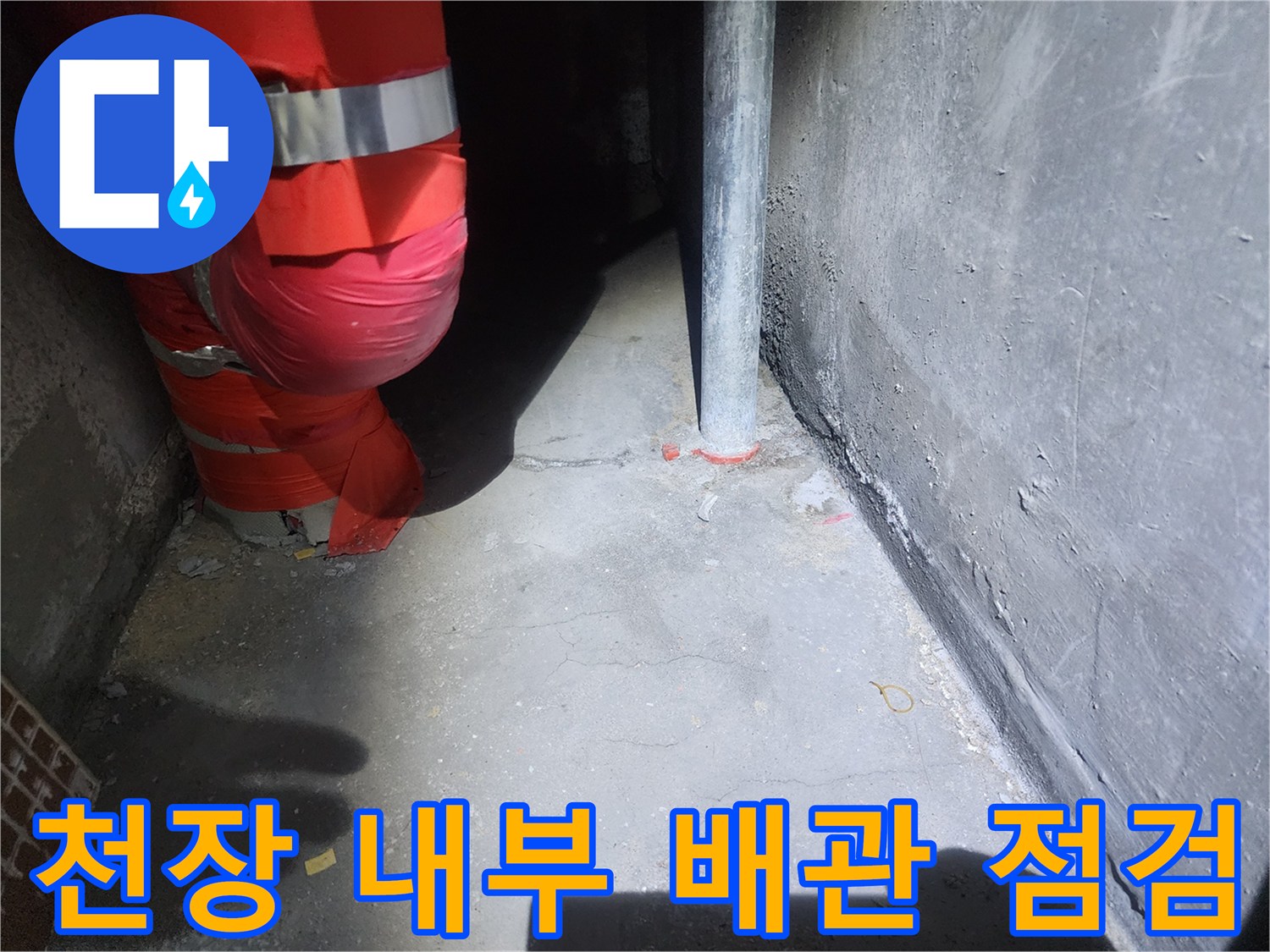 붉은색 배관 보온재와 수직 파이프가 위치한 천장 구조물 사진입니다.