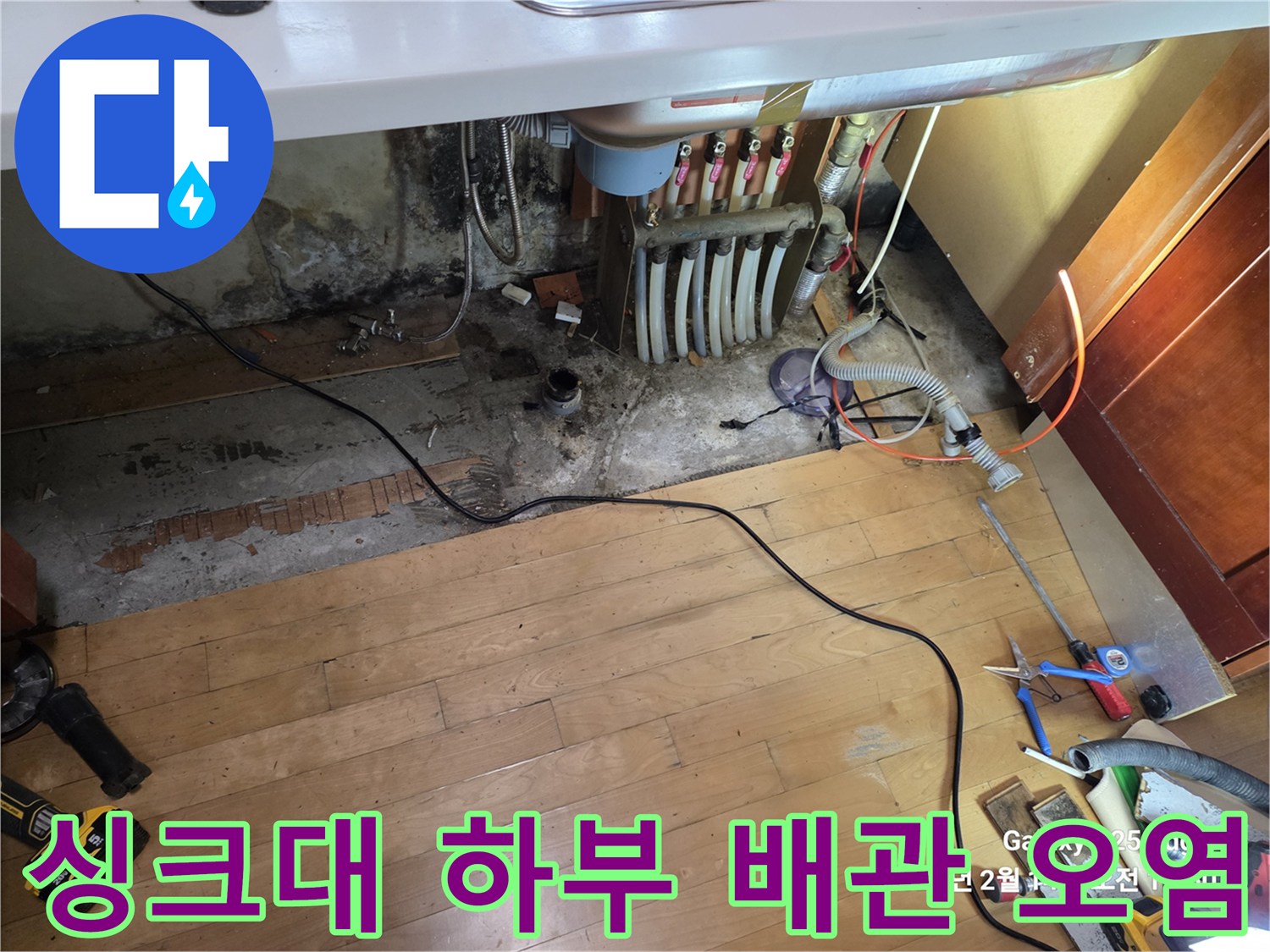 싱크대 아래 분배기 주변의 습기와 곰팡이가 발생한 바닥
