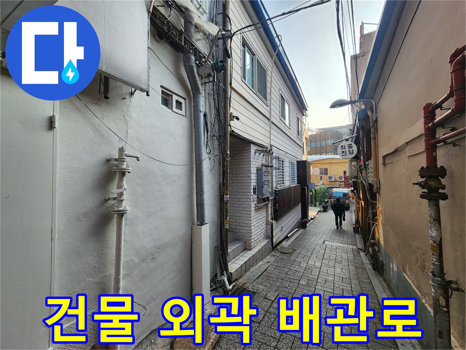 건물 사이 골목에 배치된 외부 배관 및 구조물