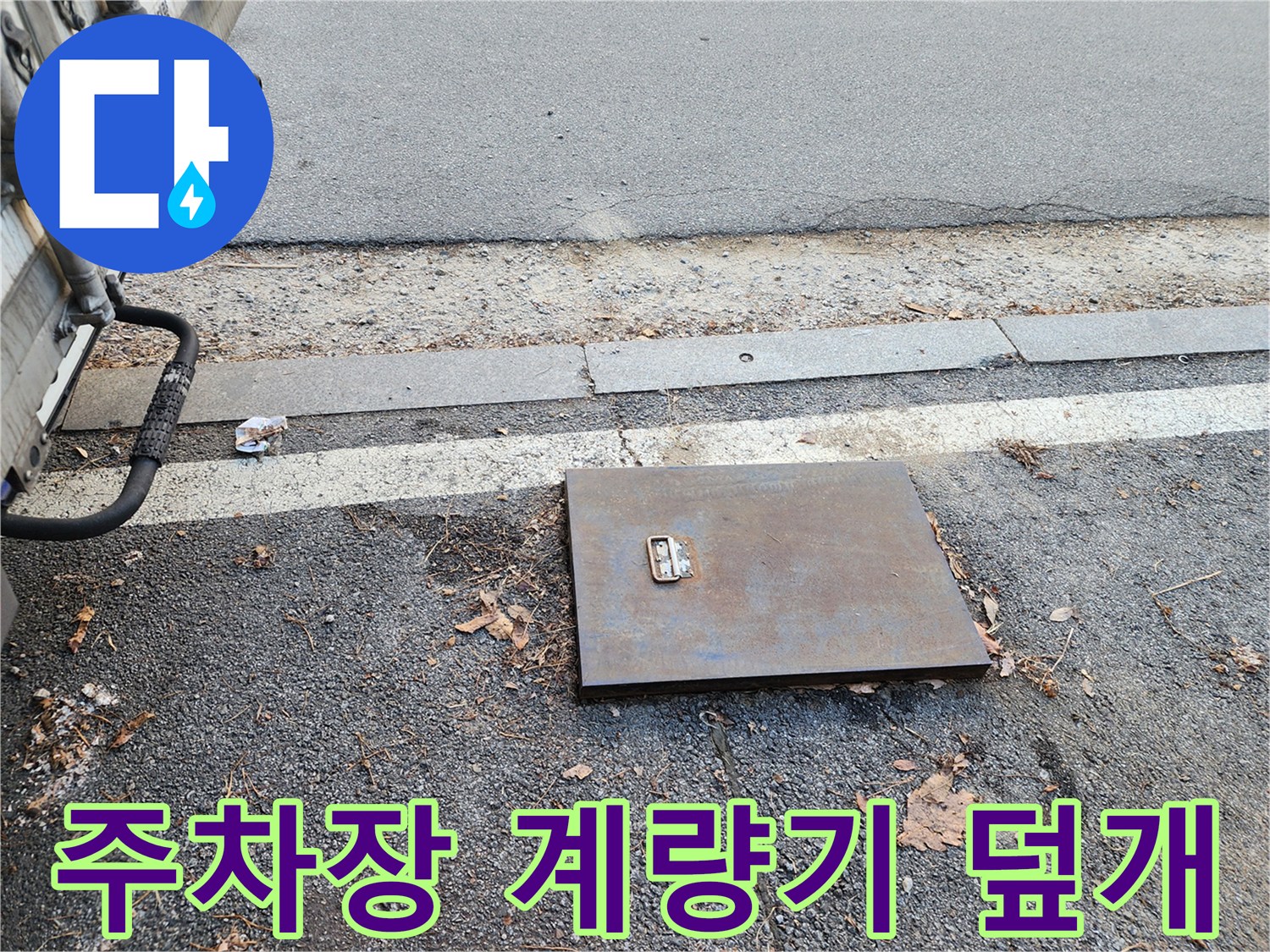 주차장 바닥에 매립된 수도 계lam기 함 덮개 모습입니다.