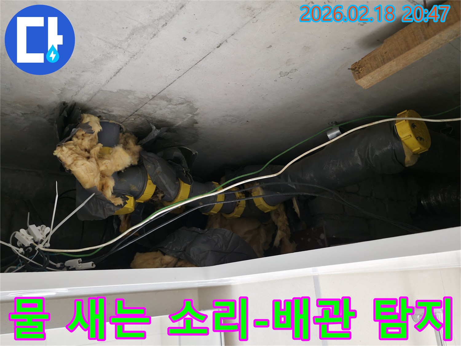 천장 속에서-누수 흔적과 함께-노출된 배관 및-손상된 단열재입니다.