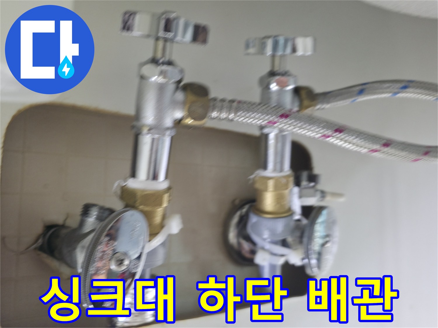 은색 금속 호스와 수도 밸브가 맞물려 있는 배관 구조