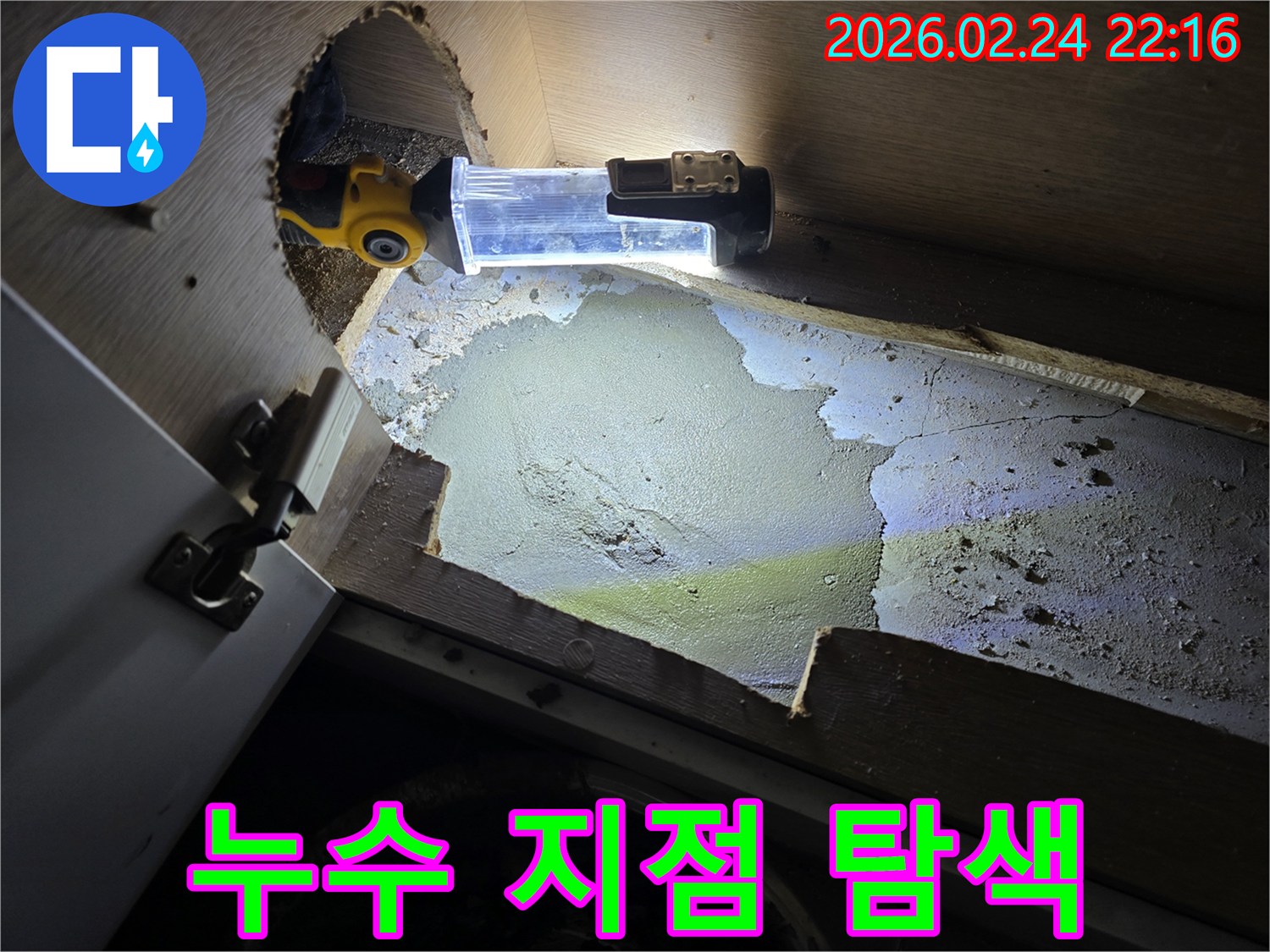 누수-엔지니어가-어둡고-좁은-공간에서-누수-지점을-찾기-위해-강력한-조명으로-구석구석-탐색하는-모습