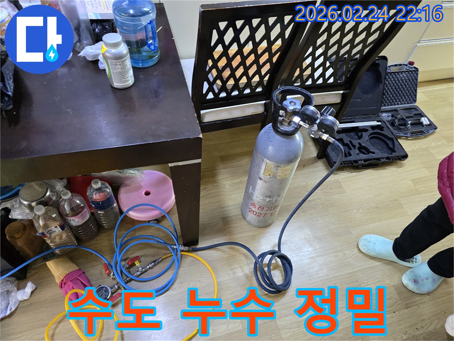 미세한 수도 누수 지점을 찾아내기 위해-가스통과 압력 게이지를 연결하여-정밀 탐지 장비를 준비하는 과정입니다