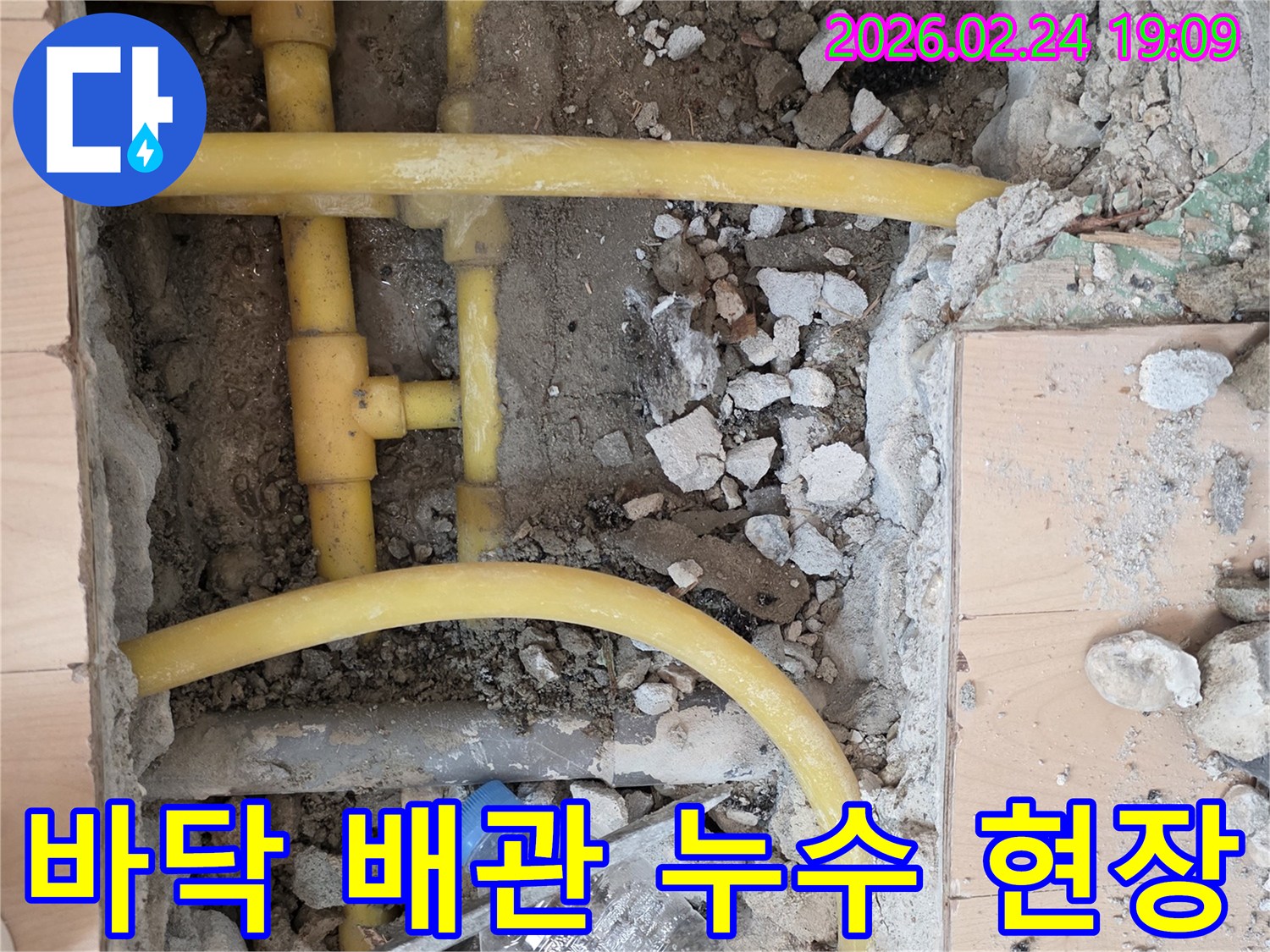 누수 공사 중 바닥을 파쇄하여 노출된 노후 배관의 상태를-정밀하게 점검하는 모습입니다.
