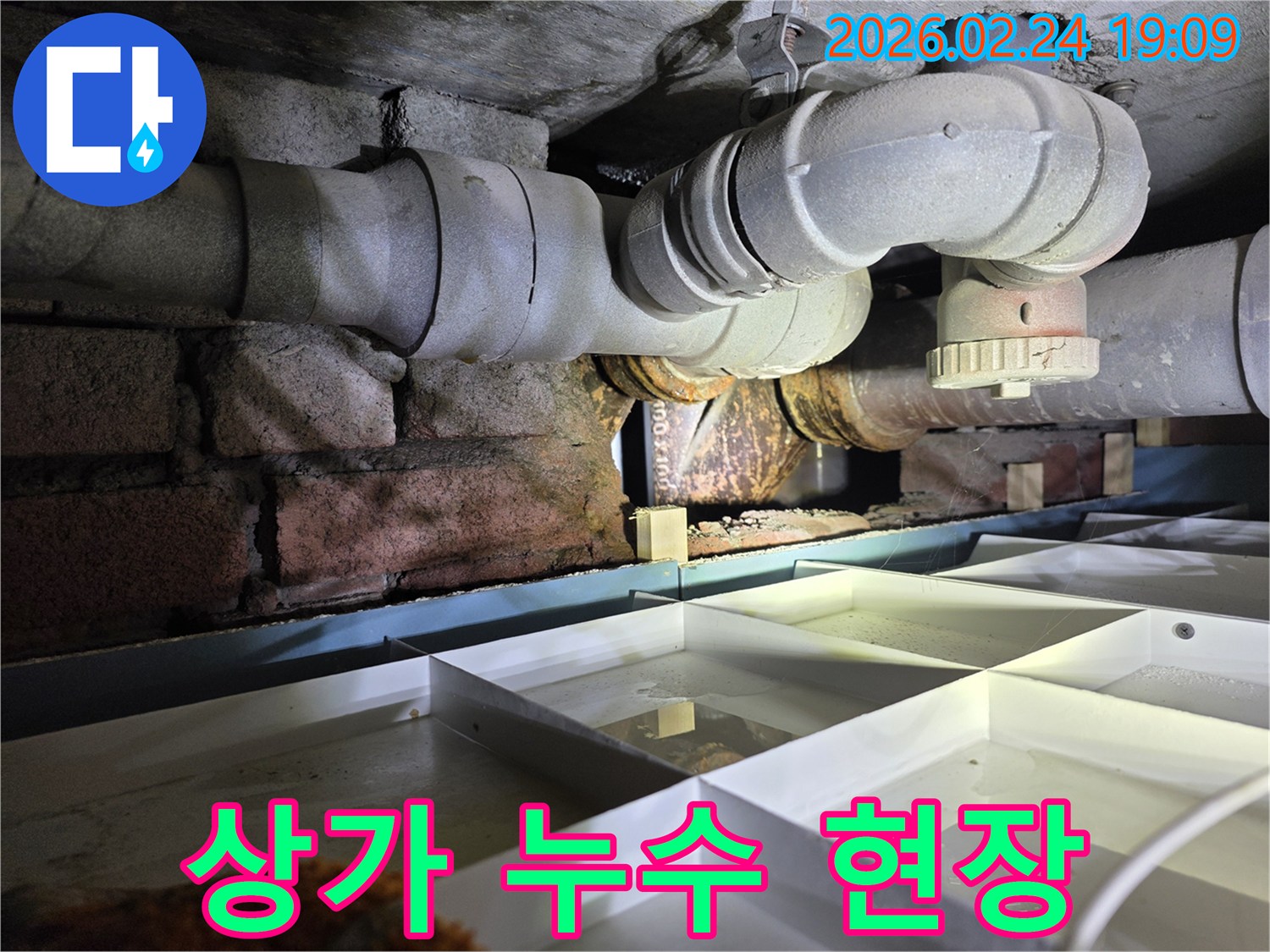 상가-건물-지하의-노후-배관에서-누수가-발생하여-물이-고인-상황을-보여주는-이미지