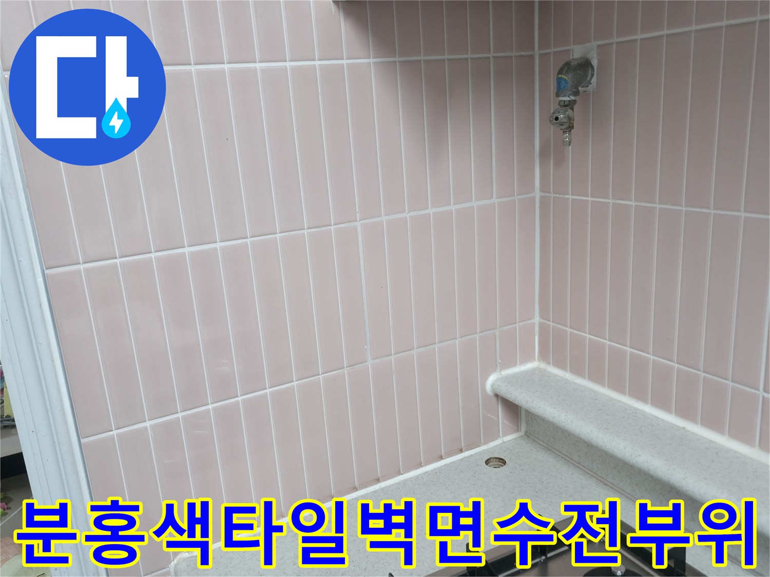 수직 타일 패턴의 벽면과 금속 재질 수도꼭지 모습