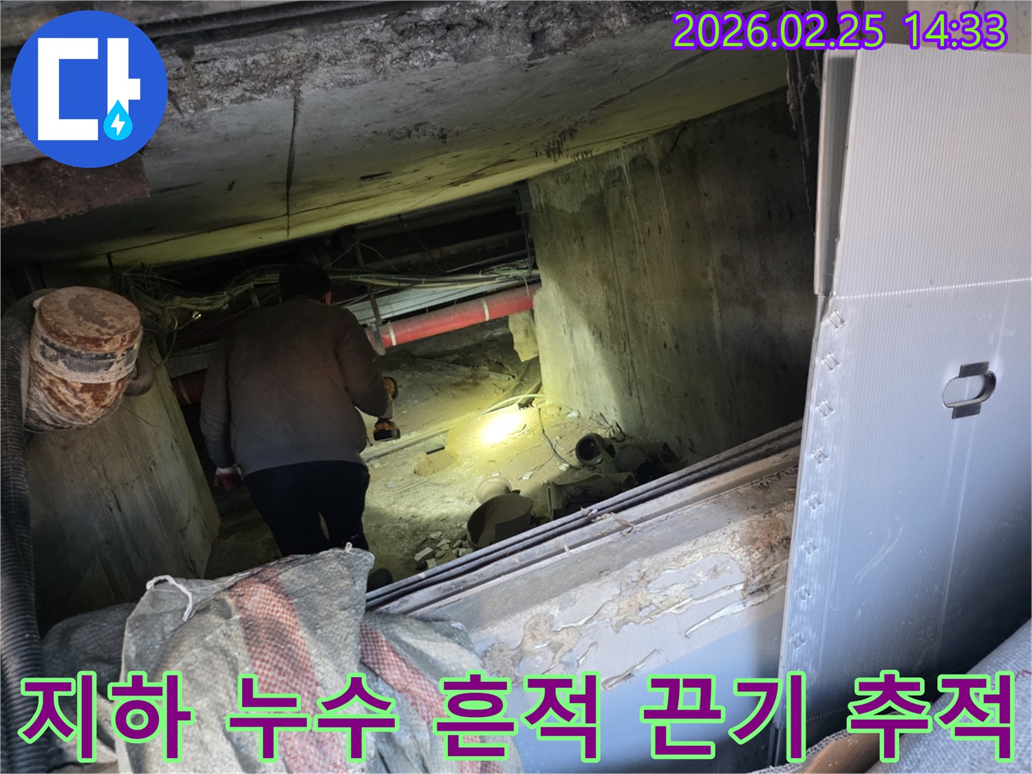 누수 전문 엔지니어가-어둡고 좁은 지하 공간에서-손전등을 비춰가며-누수 흔적을 끈기 있게-추적하는 모습입니다.