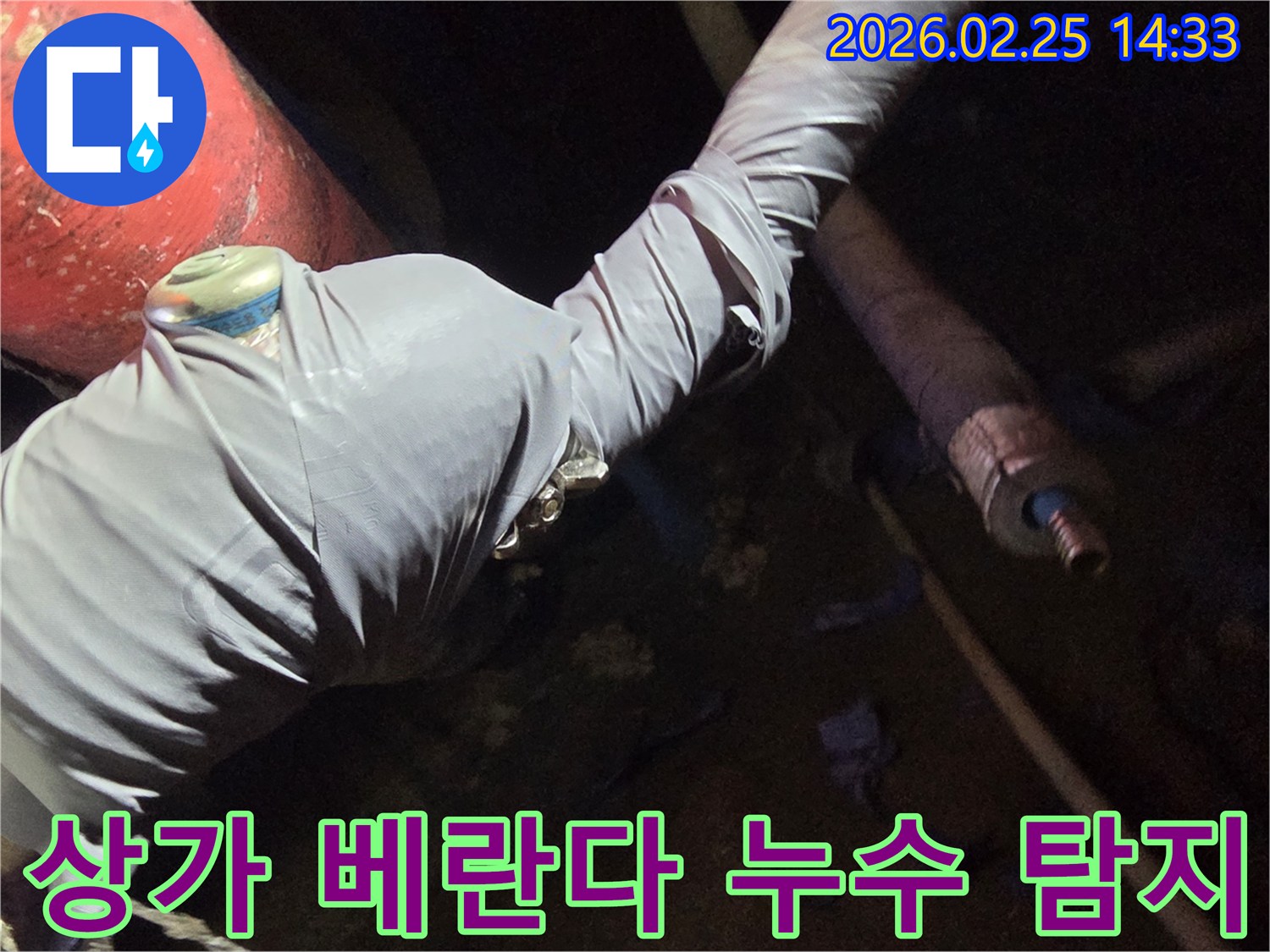 누수-전문가가-상가-베란다-누수-원인을-찾기 위해-배관에-탐지-장비를-연결하는-사진