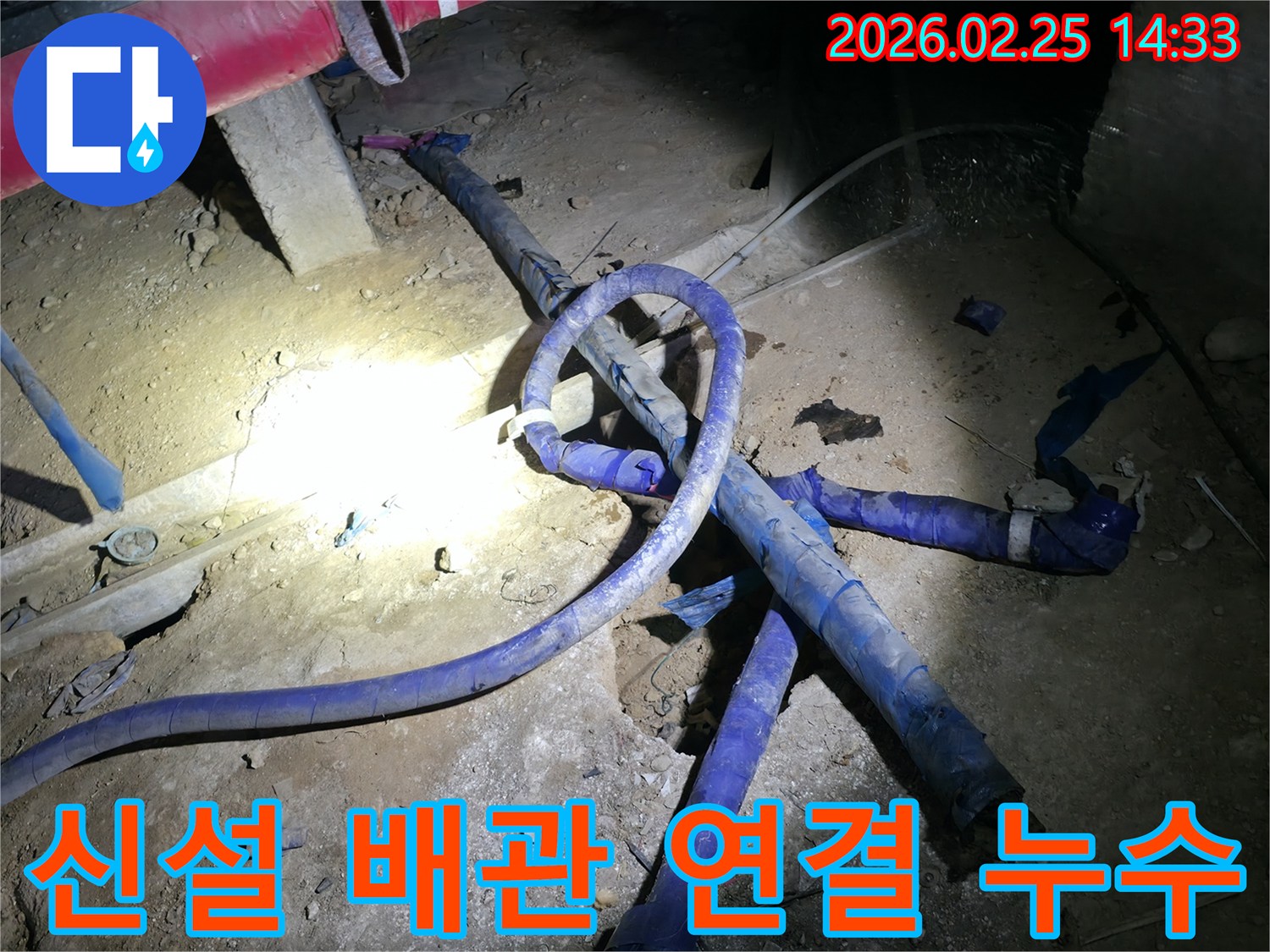 새로 설치된 배관의 연결 부위에서-발생한 누수를 점검하고-보수하는 작업 현장입니다