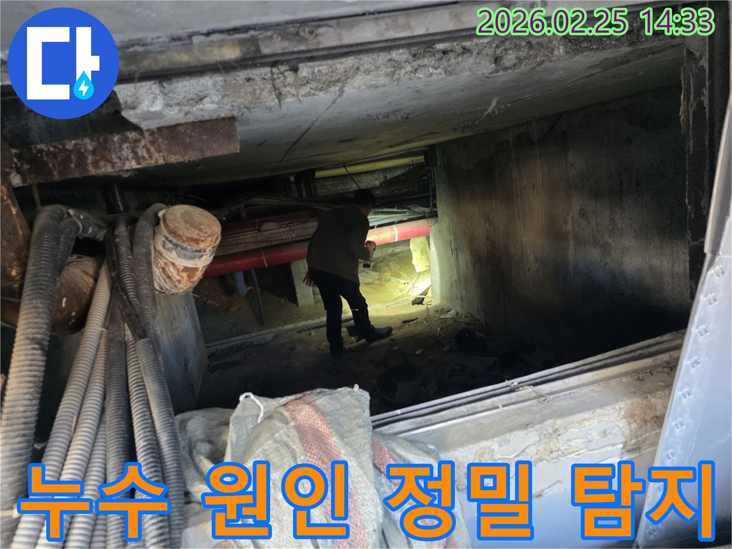 손전등을 든-누수 전문가가-복잡한 배관 사이에서-누수 지점을-확인하는 중