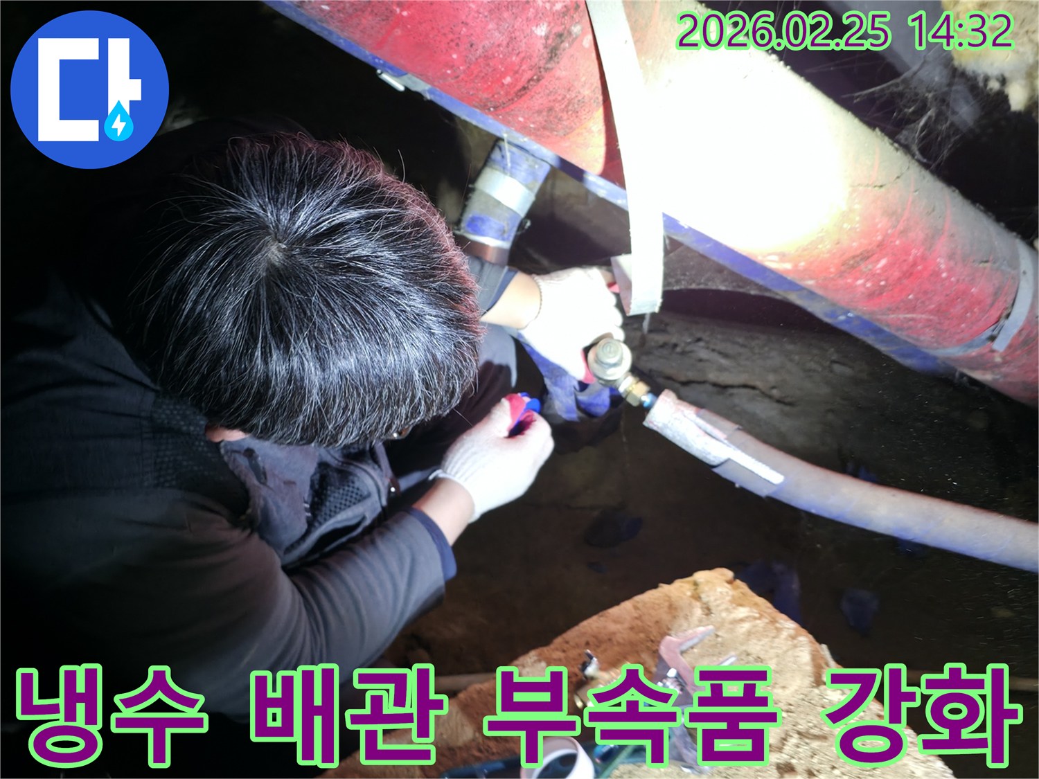 숙련된 누수 기술자가 좁은 공간에서 손전등을 비추며 냉수-배관 부속품을 정밀하게 점검하고-강화 교체하고 있습니다-냉수누수해결-전문가보수