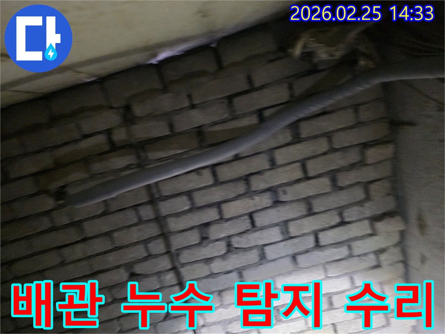 어두운 벽돌 벽면을 배경으로-단열된 배관과 함께-숨겨진 누수 지점을 탐지하고-수리하기 위해 검사되는 현장 모습입니다.