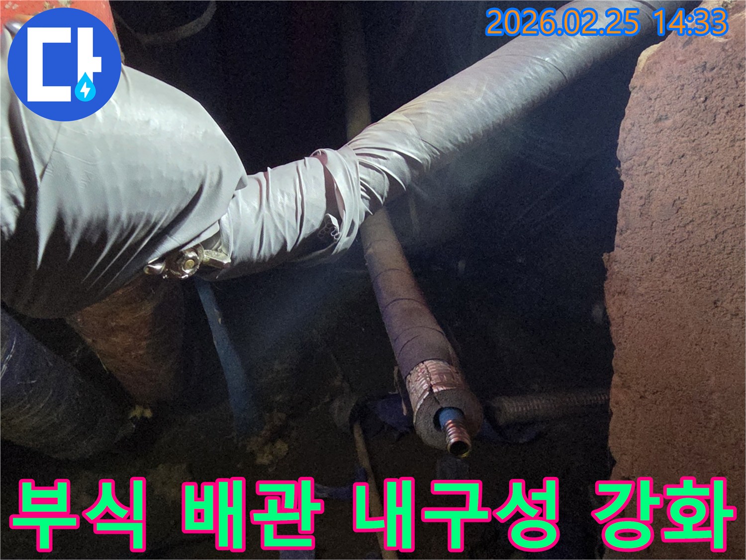 어두운 작업 공간에서-장갑을 낀 손이-부식으로 손상된 배관을-새로운 부품으로-교체하고-내구성을 강화하는-모습입니다