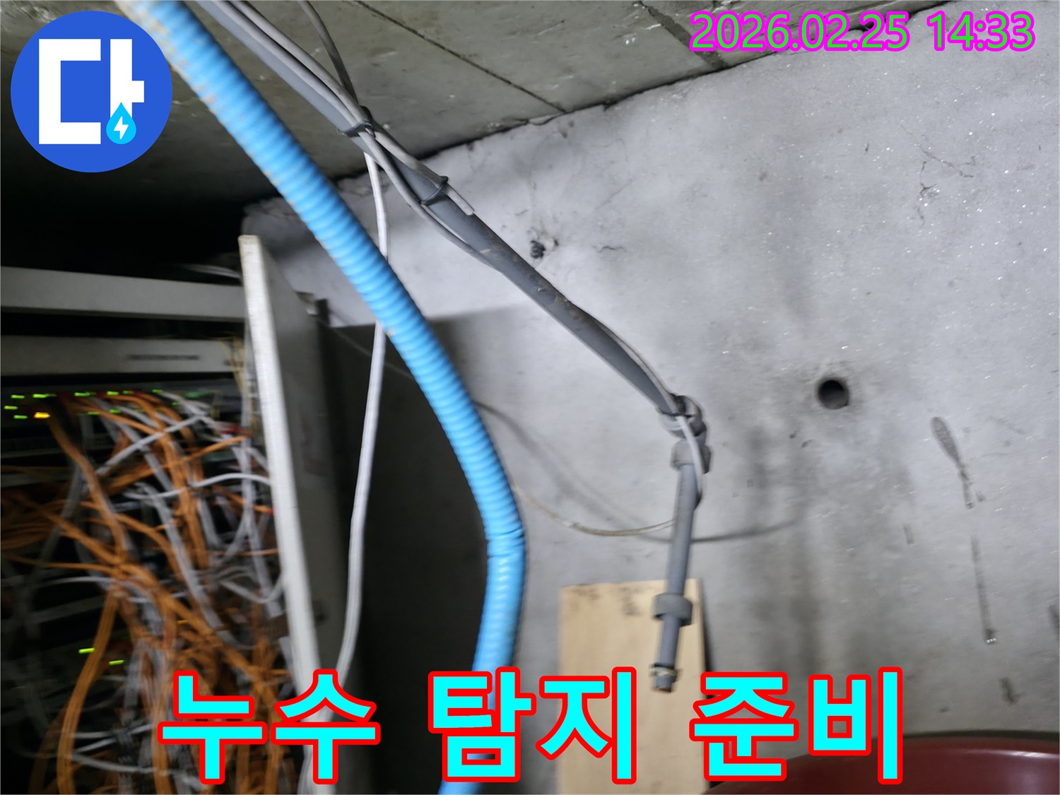 콘크리트 벽면에 고정된-파란색 주름관과 회색 케이블들이-누수 탐지 작업의-중요한 단서가 될 수 있음을-시각적으로 보여주는 현장입니다