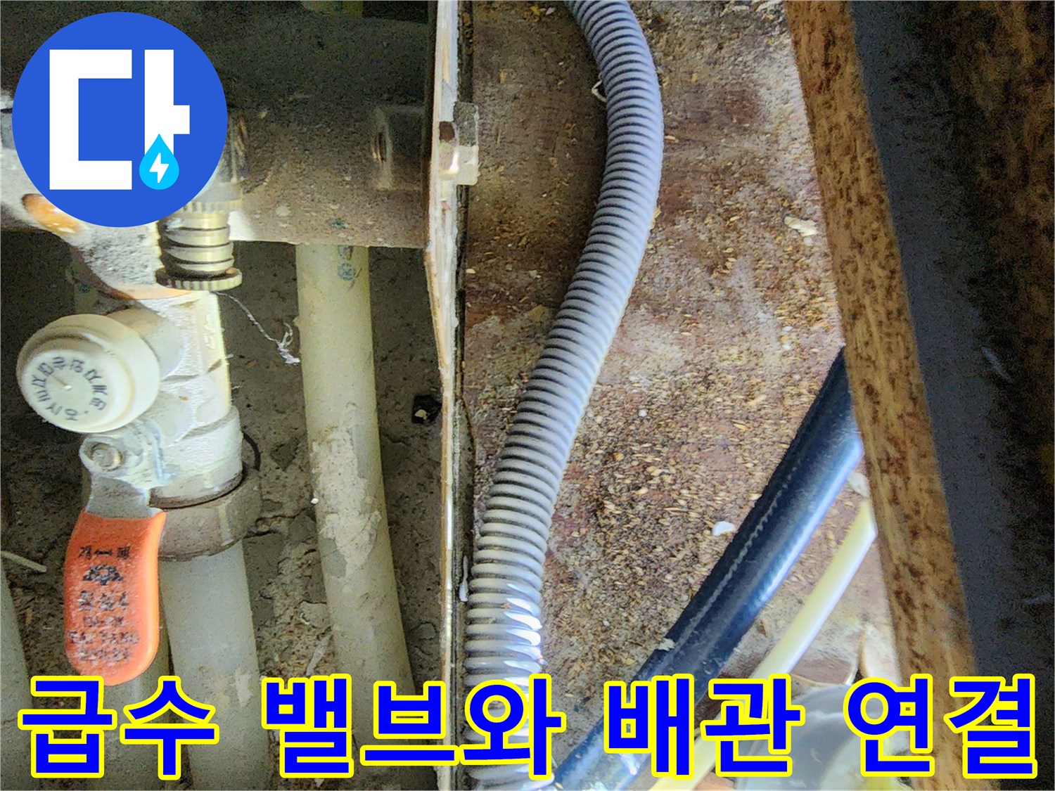 주황색 밸브 핸들과 회색 주름관이 연결된 천장 내부 모습
