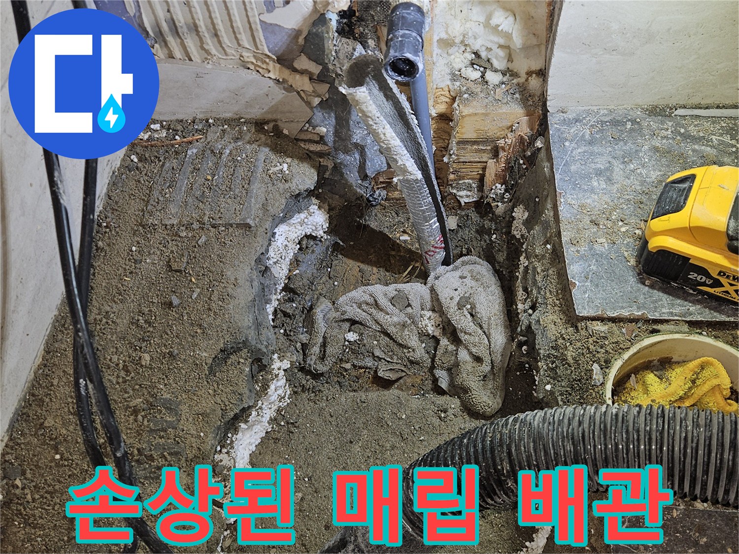 욕실 타일 아래 젖은 흙과 함께 노출된 파손된 수도 배관