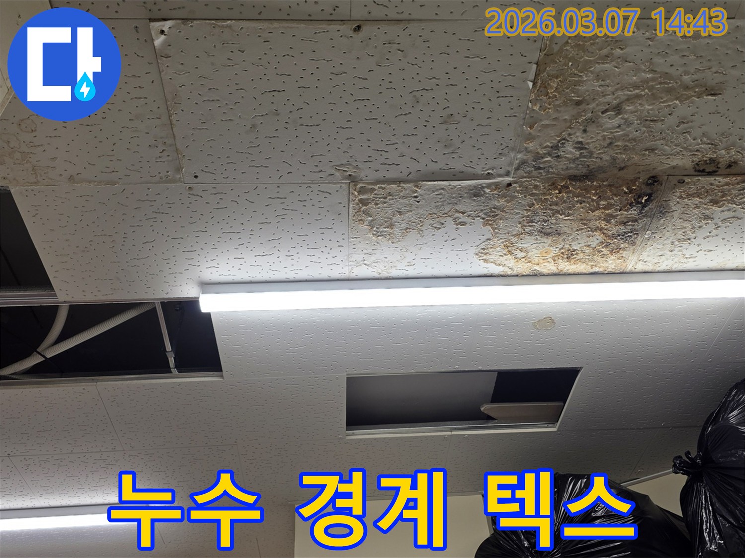 누수로-손상된-천장 텍스와-손상되지-않은-텍스의-경계가-뚜렷하게-보이는-현장-사진입니다