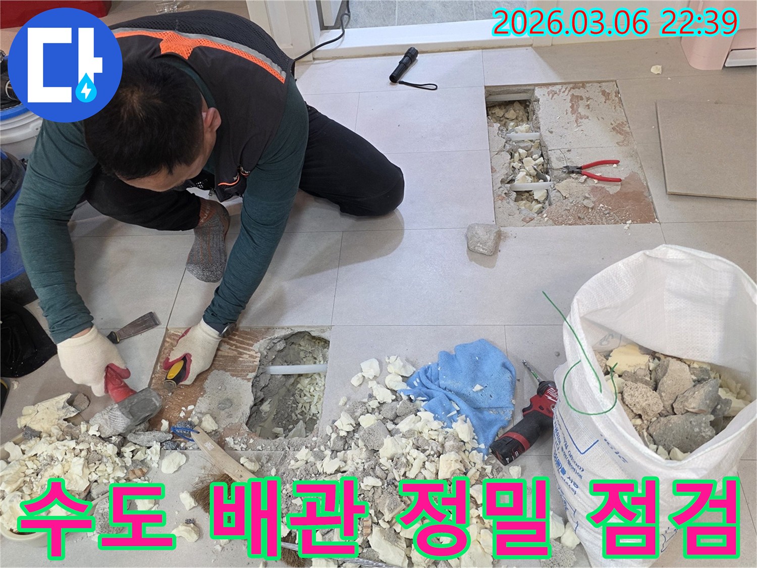 전문 누수 엔지니어가 빌라 누수 지점의-노출된 수도 배관 상태를 면밀히 점검하고-수리 계획을 세우는 장면입니다