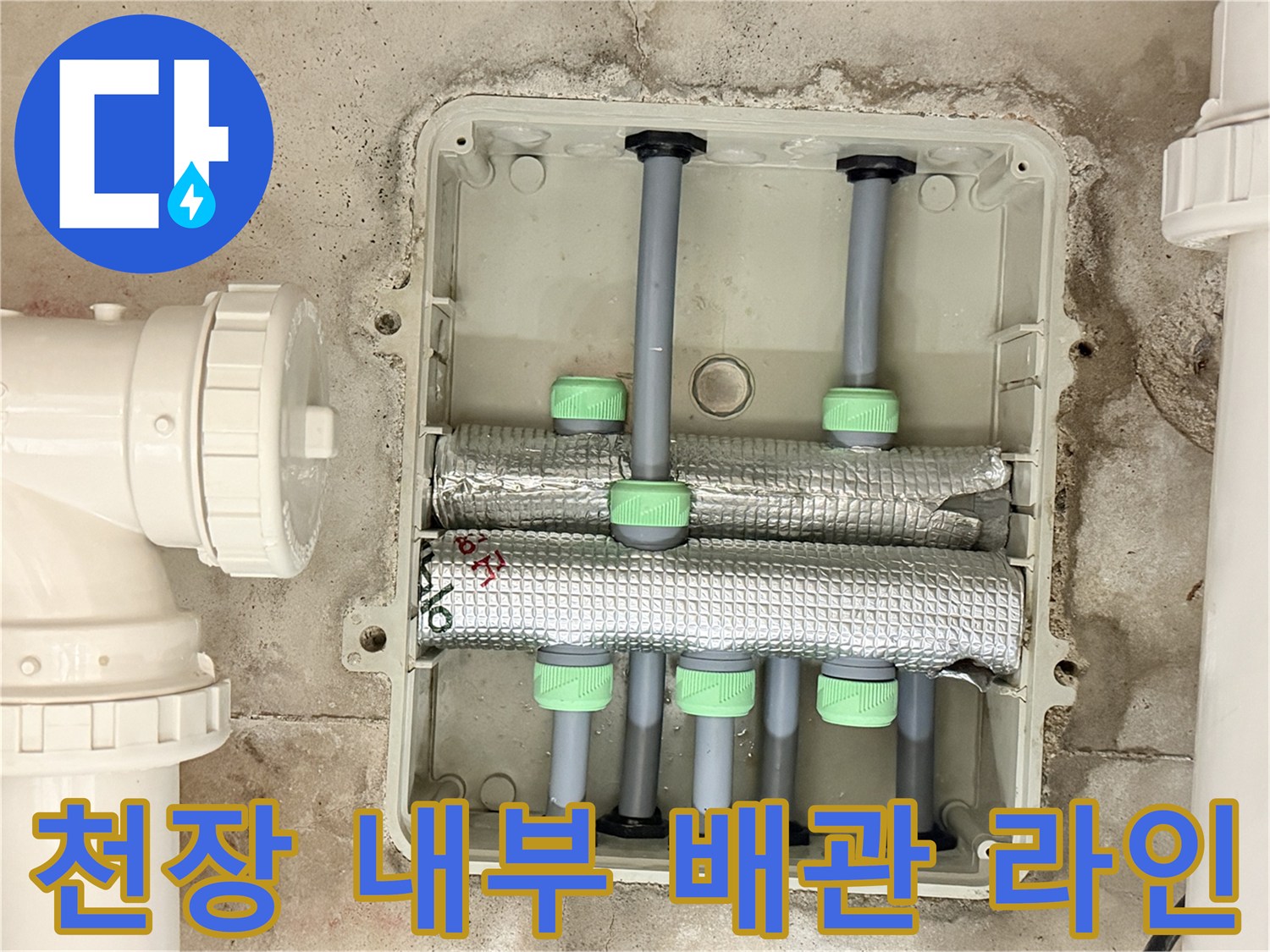 하얀색 점검구 케이스 안에 배치된 여러 갈래의 급수 배관