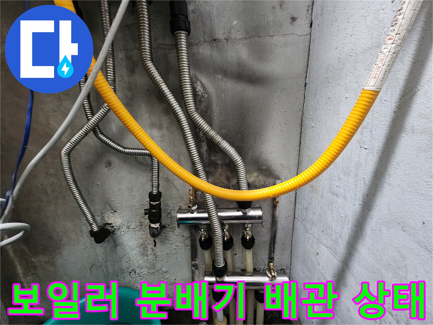 보일러실-하단-분배기와-연결된-금속-배관-및-노란색-호스-전경