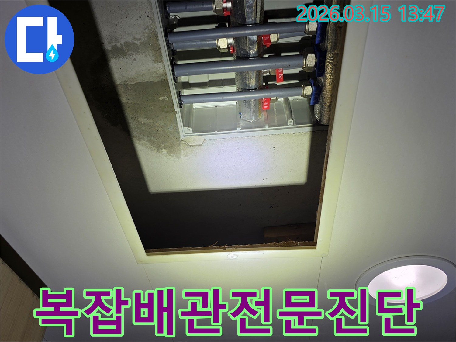 천장 개구부 아래-복잡하게 얽힌 배관 시스템을-전문가의 시선으로-정확히 진단하는 모습