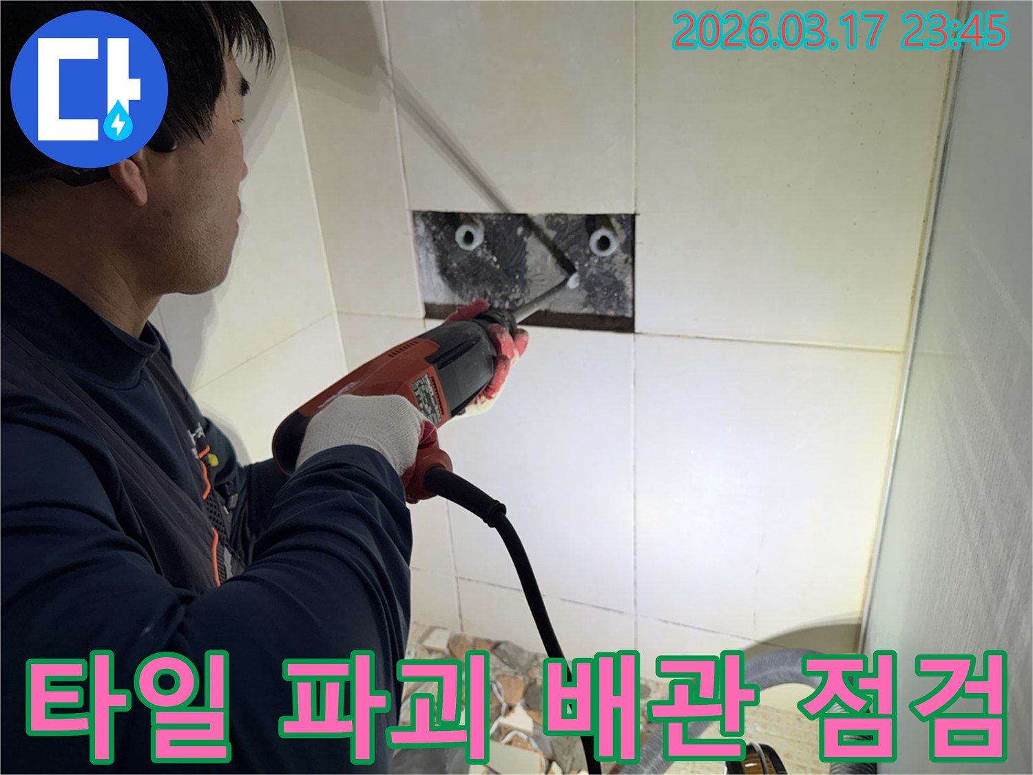 누수 전문가가 아파트 벽면 타일을 파괴하여-숨겨진 배관의 누수 지점을 육안으로 점검하는 작업 현장입니다.
