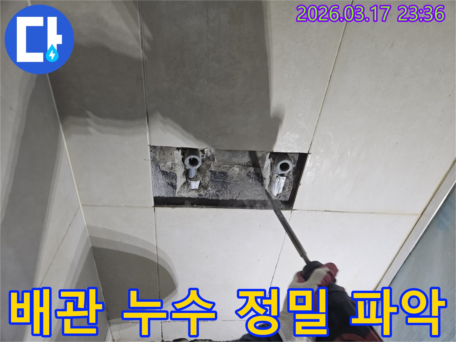 누수 해결을 위한-필수 단계로-벽면 타일 파쇄를-진행하여-배관을 확인하는-모습입니다